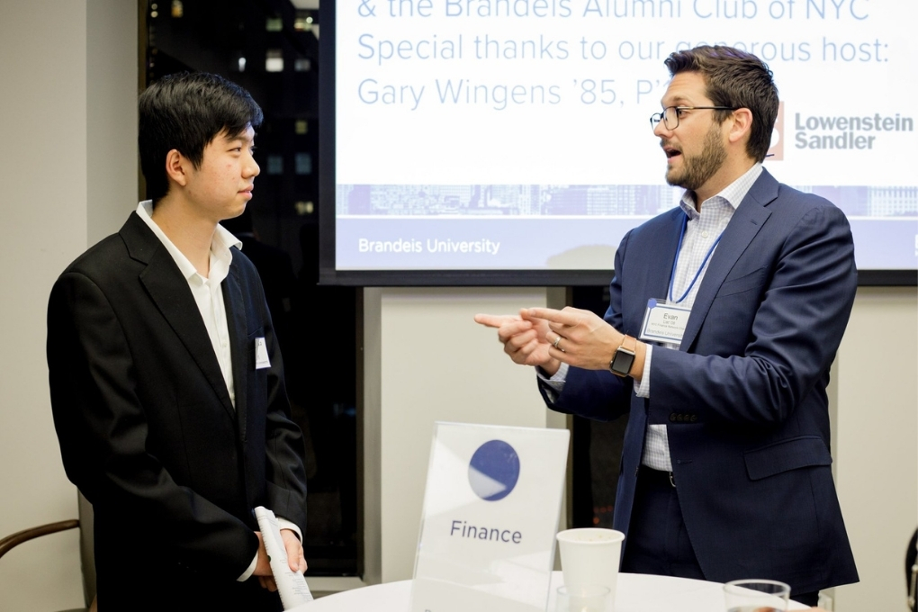 alum speaking with student at career fair
